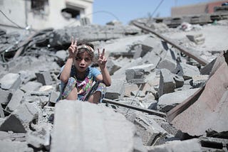 A girl sitting in the ruins of a bombed out building
