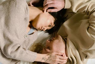 A man and a woman caressing each other’s heads