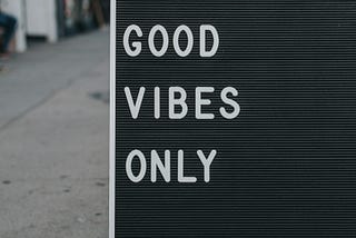 A marque on the sidewalk that says Good Vibes Only