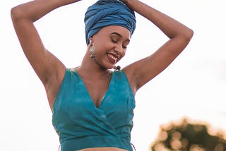 A happy young woman with her hands raise to her head