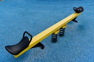 An image of a seesaw on a playground.