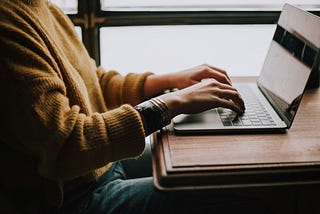 woman at a desk typing on laptop