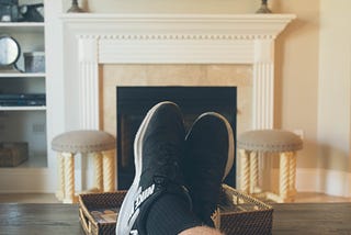 Two feet propped on a coffee table in a point-of-view shot of watching Netflix on TV