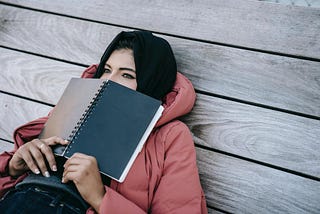 Woman with a notebook, thinking about a decision.