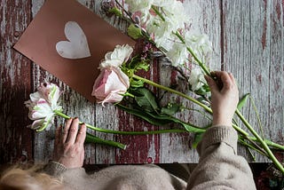 wooden table with cut fresh flowers being arranged by woman, mothers day 2024, mothers day calendar date, mothers day gift ideas, last minute mothers day gifts