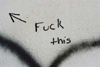 paper with words “fuck this” and an arrow