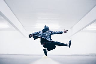 young man in an acrobatic jump with a white space background