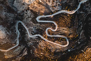 Aerial view of a steep mountain road winding through a rocky landscape