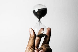 A hand holding an hour glass
