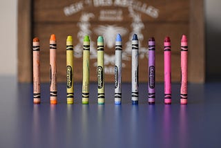 10 crayons standing up on a table