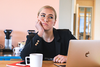 A female employee looking bored and considering quiet quitting.