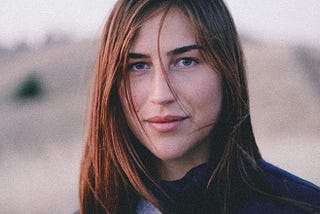 An Intriguing-looking young woman with a mysterious smile and penetraing gaze