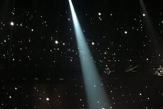 person wearing red standing in a spotlight