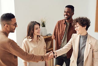 A group of people at work reaching an agreement and looking happy and satisfied with what’s being discussed