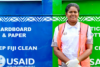 A woman stands in front of a recycling hub.