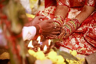 Pundit handing the bride something as she cups her hands together on her lap.