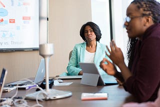 Two women in a meeting discussing requirements.