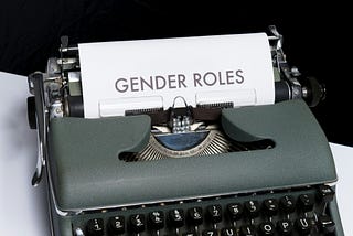 A typewriter with a paper that reads “Gender Roles”