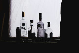 A collection of empty liquor bottles shown in black-and-white.