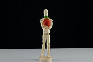 model doll holding a strawberry