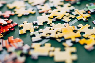 A picture of loose yellow colored jigsaw puzzle pieces