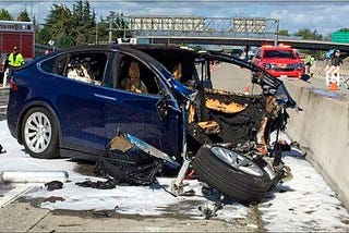 Crashed car on highway with entire front end missing, and fire suppressant foam all around.