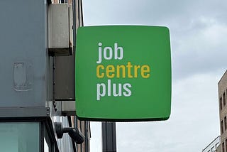 A green building sign reading “job centre plus.”