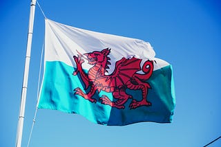 Welsh national flag: red dragon against a white sky and green ground. We win flags.