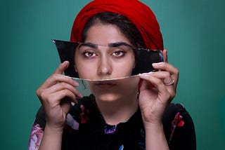 A women with a mirror over her eyes that shows her reflection of her eyes.