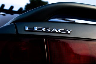 A steering wheel with the word legacy in silver.