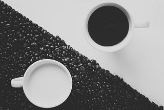 A cup of coffee and a cup of tea on a black and white yin yang background