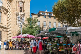 People shopping at an outdoor market in a small town in France.