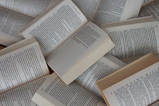 A pile of open books sprawled out on top of each other.