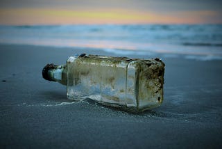 An empty liquor bottle on the ground.