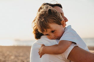 boy hugging woman during daytime