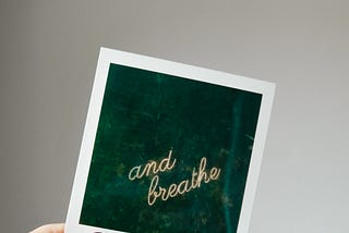 A framed poster labeled ‘and breathe’