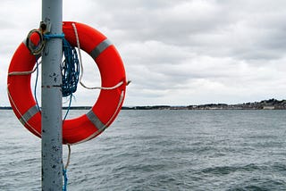 a view over the sea with a lifebuoy on a large pole