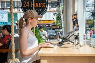 Digital nomad working from a laptop in a cafe 
Working from anywhere on a ergonomic laptop stand