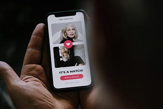 human hands holding a smartphone with dating-matching app on screen