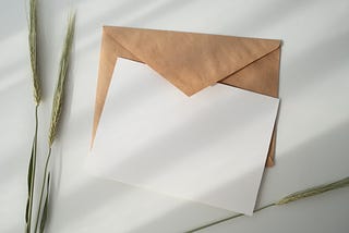 A brown envelope underneath a white blank card