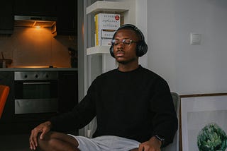 Man sitting with his eyes closed and wearing headphones.