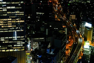 A panoramic view of a large city from a high vantage point during the night.