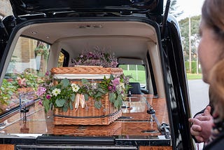 Looking at a casket in the back of a hearse