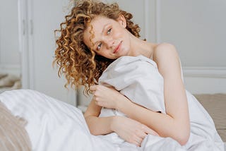 A Woman Sitting on the Bed, Waking Up Happily. What happens when you follow Jeff Bezos’s 1-hour, no-scrolling rule in the morning for 15 days? Does your mental health and productivity improve?