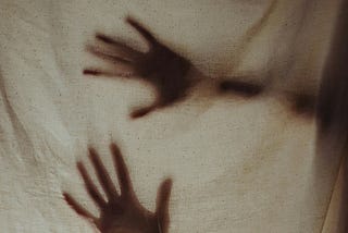 Imager of ghostly hands behind a sheet