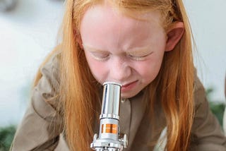 A girl looking in to the microscope.