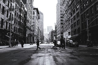 City street with people walking, a black and white photograph.