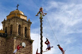 Four people being twirled on ropes high above the ground