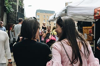 Strangers talking to each other in a public market.