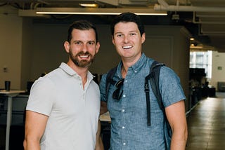 Tim stands side by side with Justin, our Chief Product Officer, both smiling at a company event.